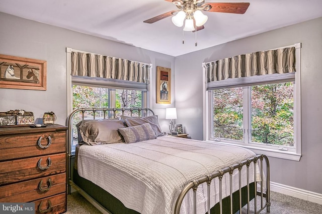 bedroom with ceiling fan, baseboards, and carpet flooring