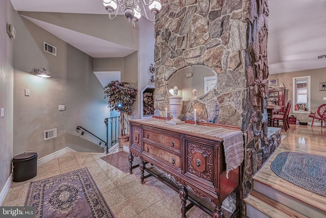 interior space with granite finish floor, baseboards, visible vents, and an inviting chandelier