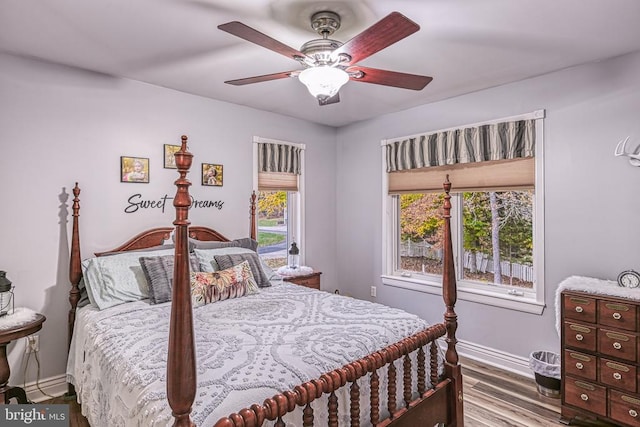 bedroom featuring a ceiling fan, baseboards, and wood finished floors