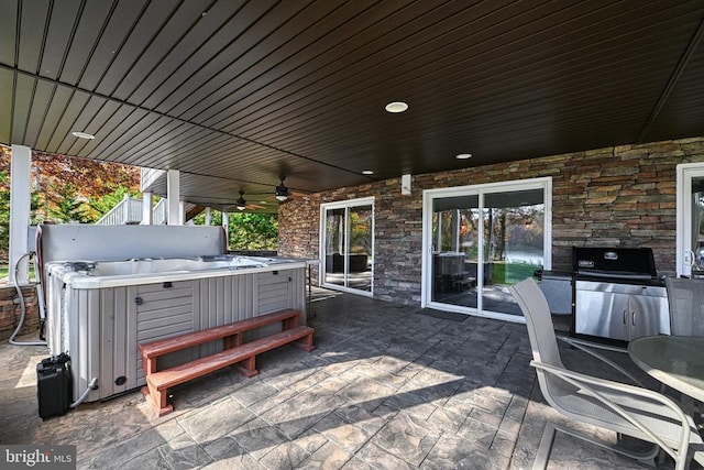 deck with a ceiling fan, a grill, a patio, and a hot tub