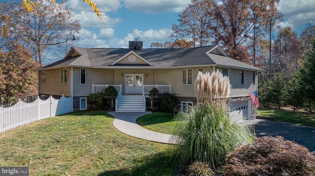 view of front of home with french doors, a chimney, a front yard, fence, and a garage