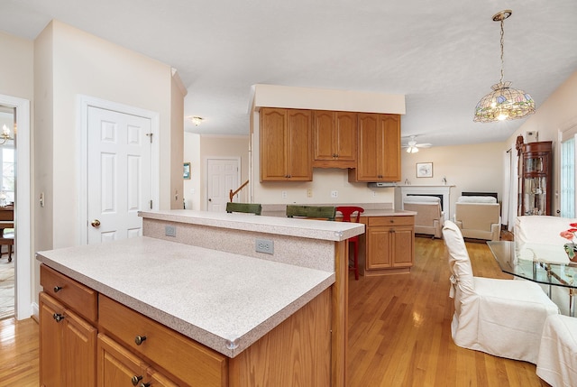 kitchen featuring light countertops, a kitchen island, light wood finished floors, and open floor plan