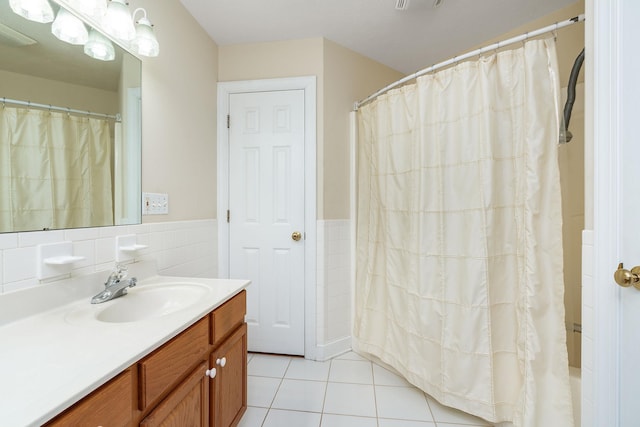 full bathroom with tile patterned floors, tile walls, wainscoting, and vanity