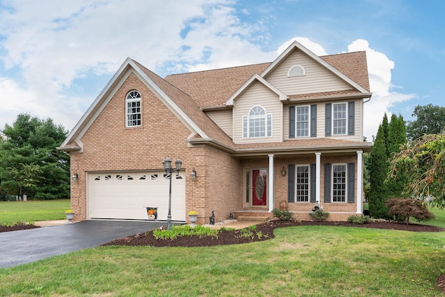 traditional home with an attached garage, a front yard, brick siding, and aphalt driveway