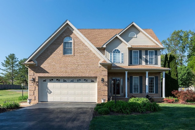 view of front facade featuring a garage, covered porch, a front lawn, and aphalt driveway