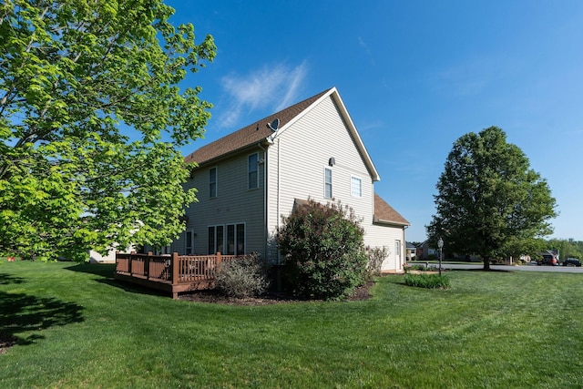 view of side of home featuring a yard and a deck