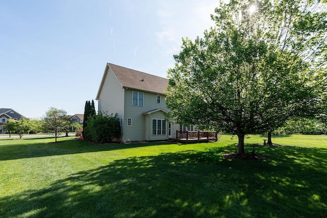 rear view of house with a yard and a deck