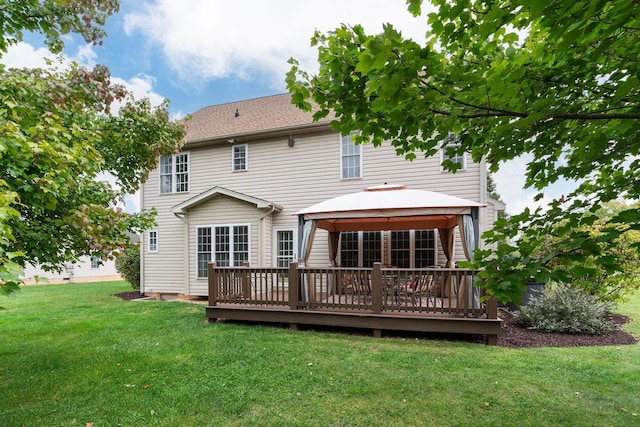 rear view of property featuring a lawn, a gazebo, and a deck