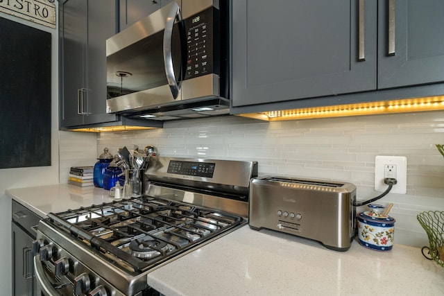 kitchen with tasteful backsplash, light stone countertops, and stainless steel appliances