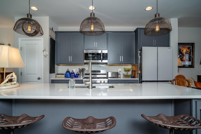 kitchen featuring stainless steel appliances, decorative backsplash, recessed lighting, and a breakfast bar area