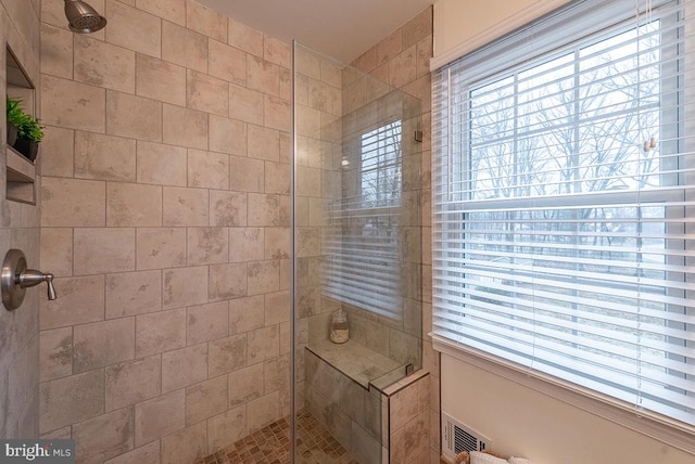 full bathroom with a tile shower and visible vents