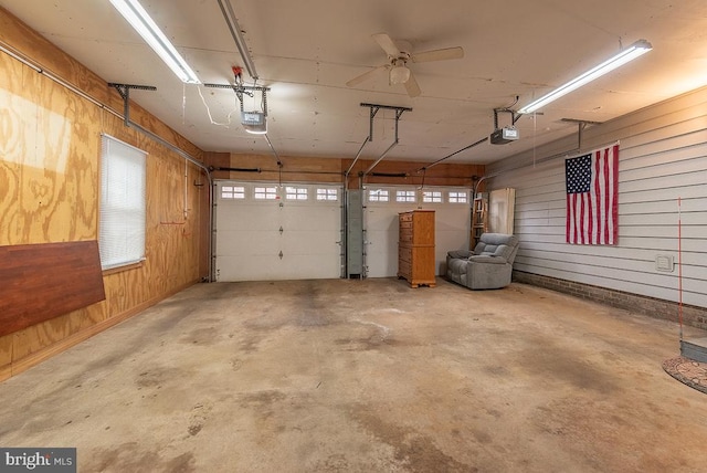 garage with a garage door opener and wood walls