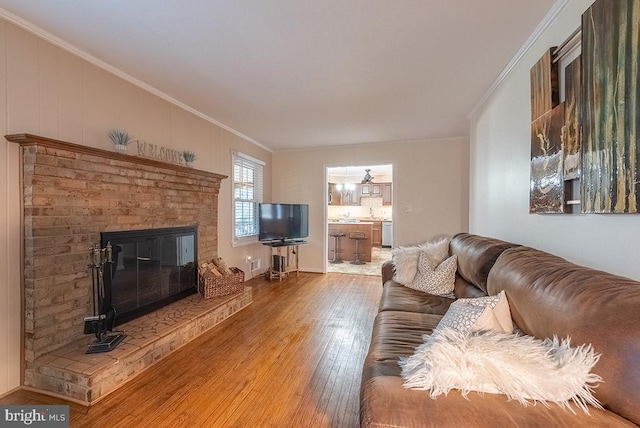 living area featuring a fireplace, crown molding, and hardwood / wood-style floors