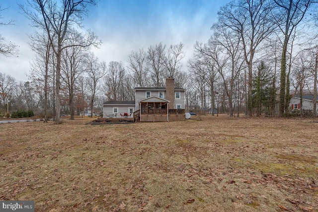 back of property featuring a chimney and a wooden deck