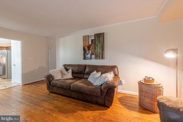 living room with light wood-style flooring, baseboards, and crown molding