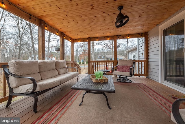 sunroom featuring rail lighting, wood ceiling, and a healthy amount of sunlight