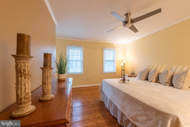 bedroom with a ceiling fan, baseboards, ornamental molding, and wood finished floors