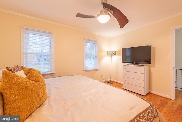 bedroom with ceiling fan, ornamental molding, light wood-type flooring, and baseboards