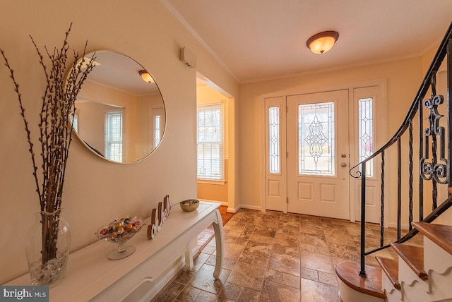 foyer entrance featuring ornamental molding, baseboards, stone tile floors, and stairs