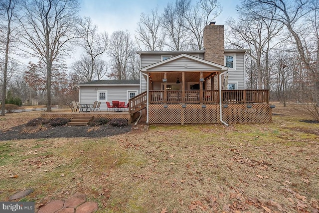 rear view of house featuring a deck and a chimney