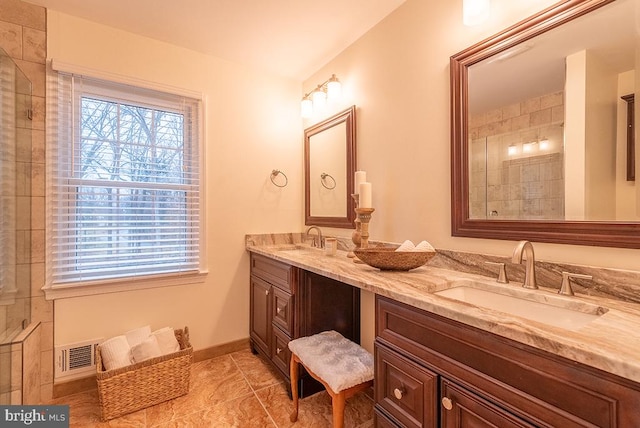 bathroom featuring double vanity, baseboards, visible vents, and a sink