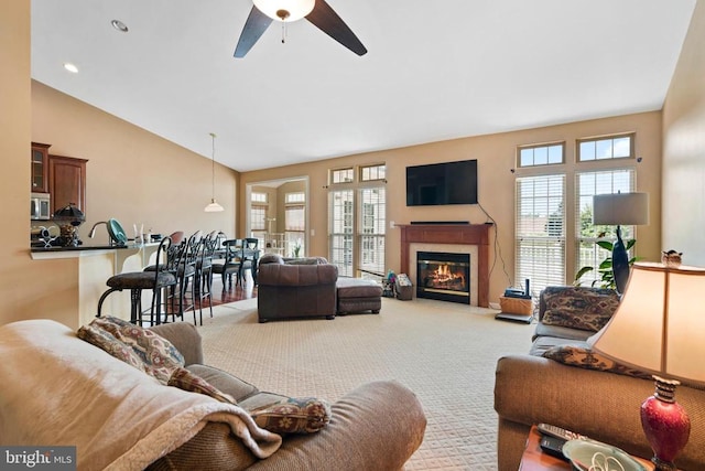 carpeted living room with high vaulted ceiling and ceiling fan