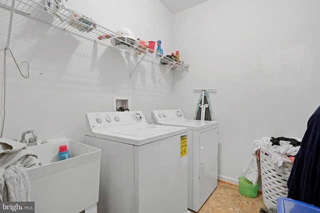 clothes washing area featuring sink, washer and dryer, and light tile patterned floors