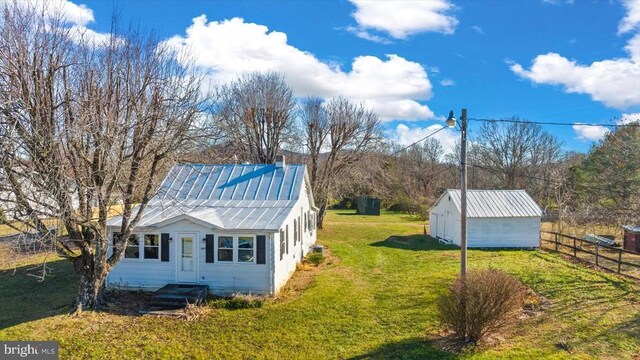 view of side of property featuring an outdoor structure and a lawn