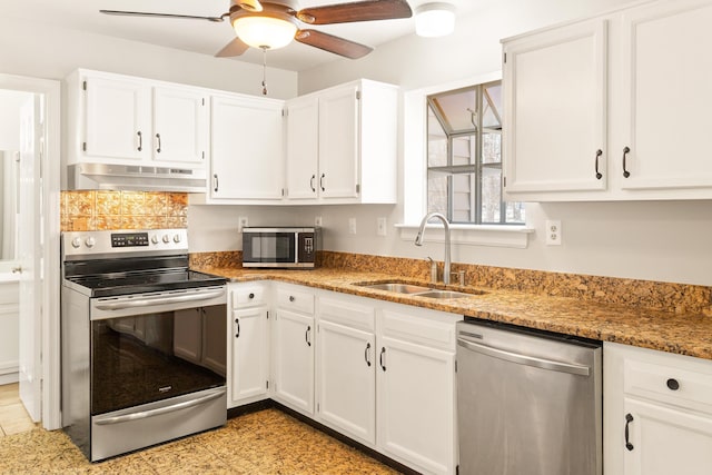 kitchen featuring stainless steel appliances, sink, white cabinets, and dark stone counters