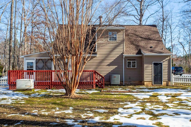 snow covered rear of property featuring a deck