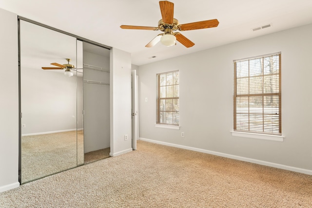 unfurnished bedroom with ceiling fan, carpet flooring, and a closet