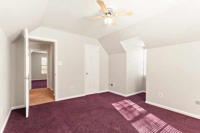 additional living space featuring ceiling fan, vaulted ceiling, and dark colored carpet