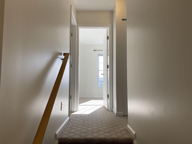 corridor featuring baseboards and carpet