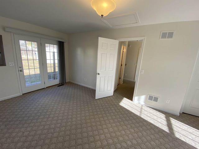 empty room with visible vents, attic access, and baseboards