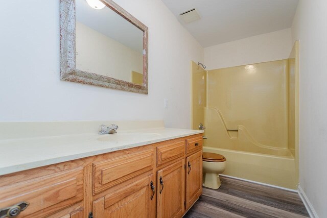 full bathroom featuring vanity, hardwood / wood-style floors, bathtub / shower combination, and toilet