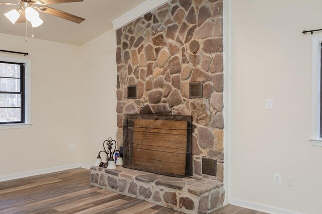 details featuring wood-type flooring, a stone fireplace, and ceiling fan