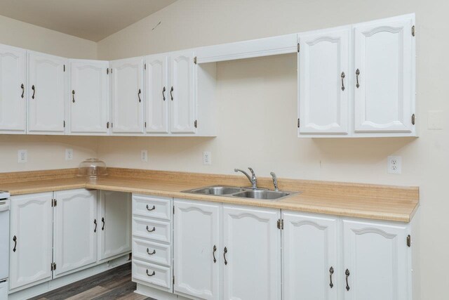 kitchen featuring dark hardwood / wood-style flooring, sink, and white cabinets