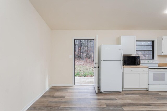 kitchen with white cabinets, white appliances, and light hardwood / wood-style floors