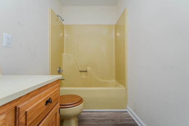 full bathroom with vanity, bathtub / shower combination, hardwood / wood-style floors, and toilet