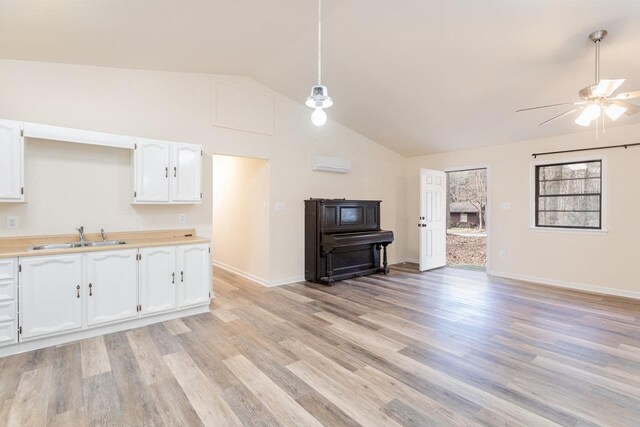 kitchen featuring pendant lighting, sink, light hardwood / wood-style floors, and white cabinets