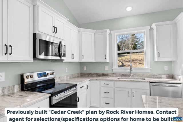 kitchen featuring appliances with stainless steel finishes, sink, white cabinets, and light stone counters