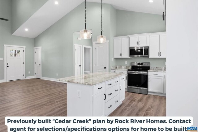 kitchen with white cabinetry, stainless steel appliances, a center island, and light stone countertops