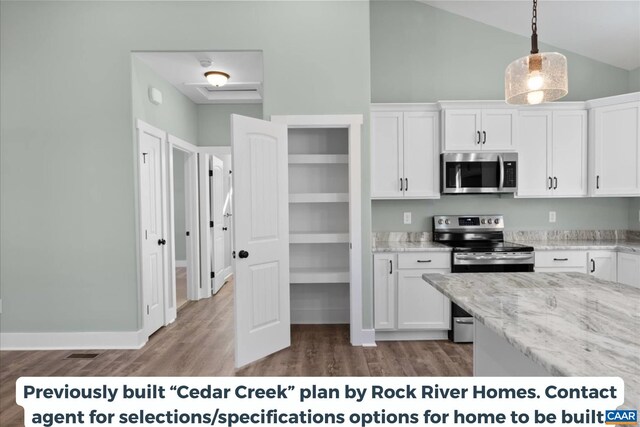 kitchen featuring hanging light fixtures, light stone countertops, white cabinets, and appliances with stainless steel finishes