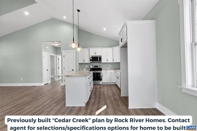 kitchen with appliances with stainless steel finishes, white cabinetry, hanging light fixtures, a center island, and light stone counters