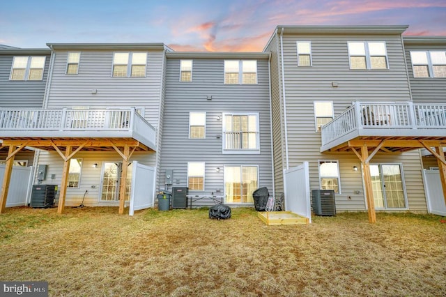 rear view of property with a yard and cooling unit