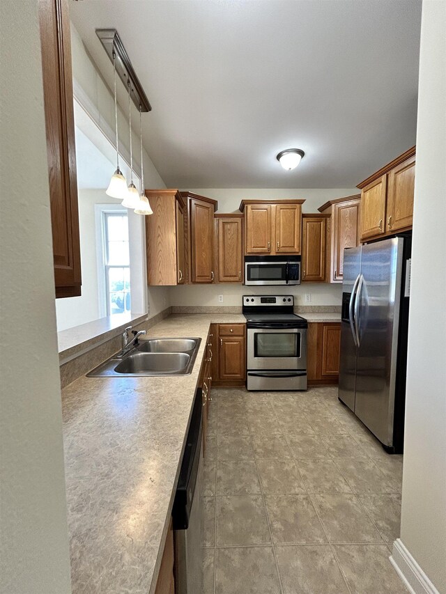 kitchen featuring sink, decorative light fixtures, and stainless steel appliances