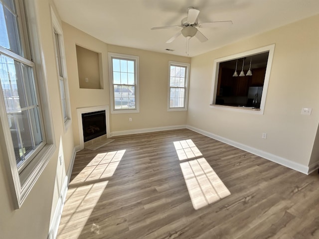 unfurnished living room with hardwood / wood-style flooring and ceiling fan