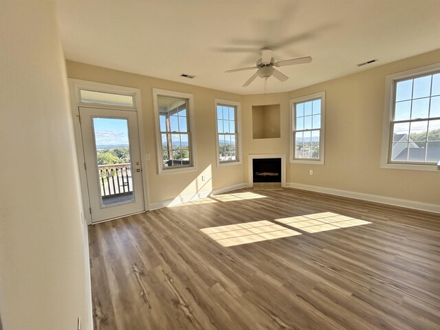 unfurnished living room featuring ceiling fan and hardwood / wood-style floors