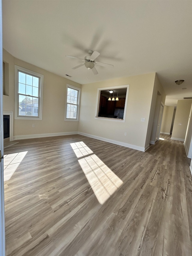 unfurnished living room featuring ceiling fan and light hardwood / wood-style flooring