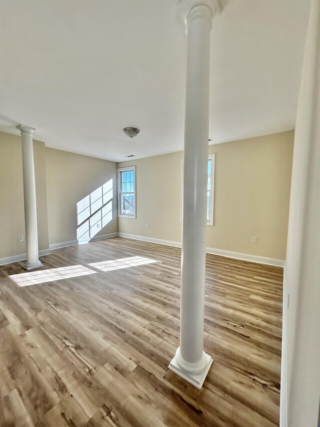 unfurnished living room featuring light hardwood / wood-style flooring and ornate columns